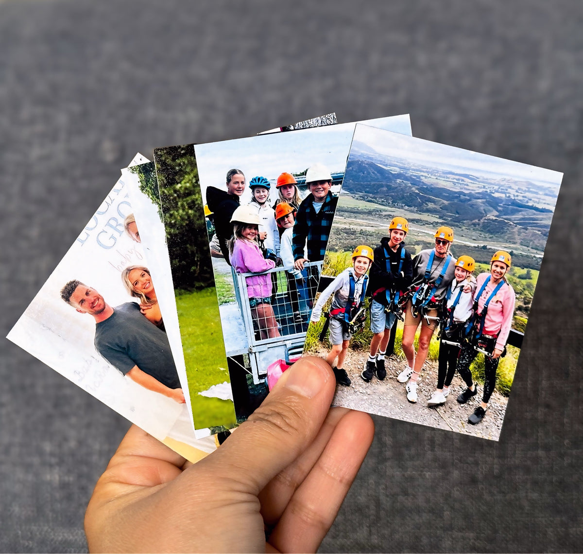 A hand fanning out a stack of printed photo magnets